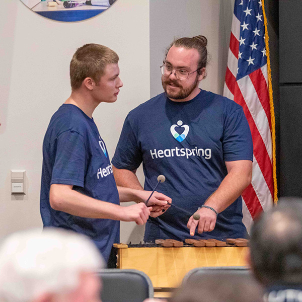 Gabe Brooking helps a student during a music program.