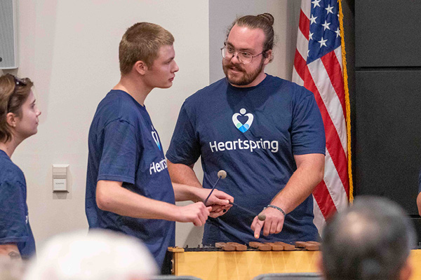 Gabe Brooking helps a student during a music program.