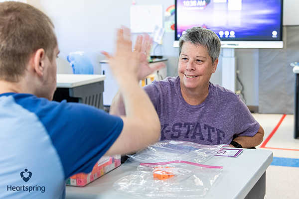 Lisa Jones high-fiving a student while working on a matching assignment.